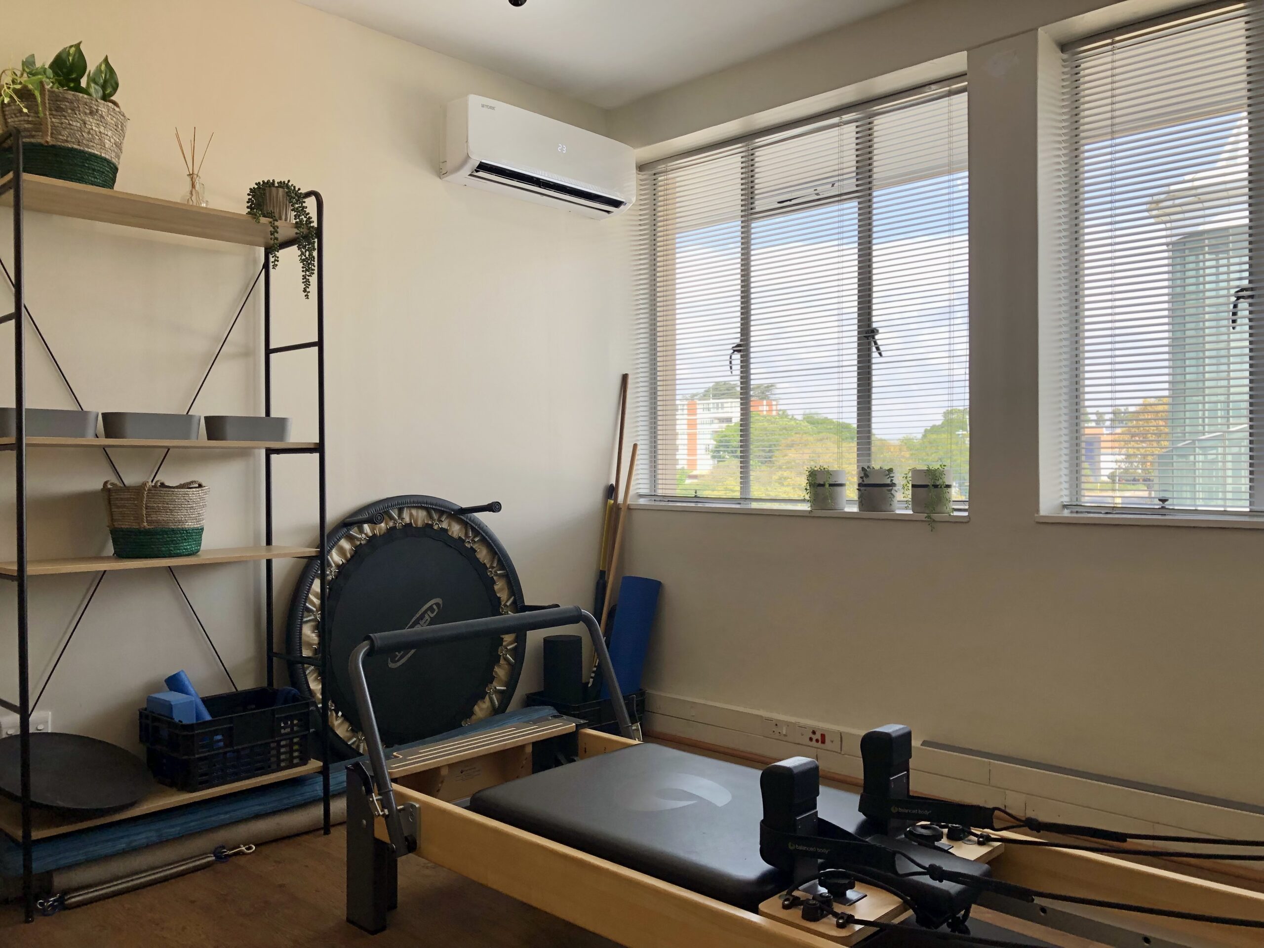 Photo of the Pilates area at Hyde Park Physiotherapy showing a Pilates Reformer, general rehabilitation equipment, and a shelf in the background
