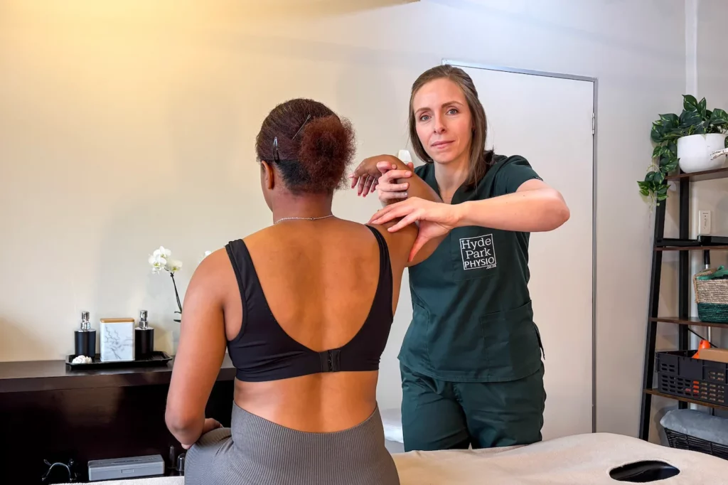Physiotherapist assesses shoulder patient in the treatment area at Hyde Park Physiotherapy Sandton